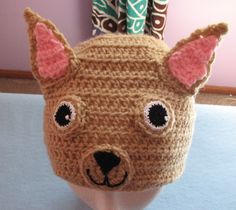 a crocheted hat with ears and eyes on top of a mannequin head