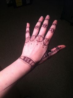 a person's hand with some tattoos on it