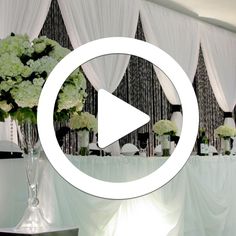 a table topped with white flowers and vases