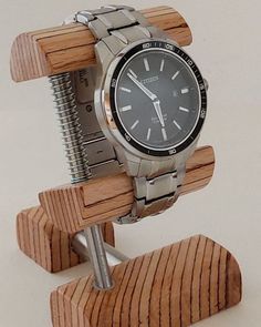 a watch on a stand made out of wood