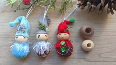 three ornaments are sitting on a table next to some pine cones and other holiday decorations