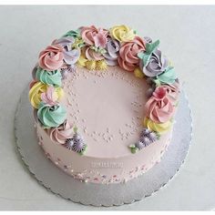 there is a cake decorated with flowers on the top and bottom layer, in pastel colors