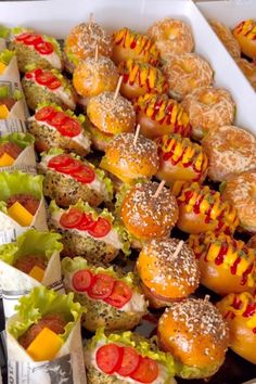 a tray filled with mini sandwiches covered in cheese and toppings on top of each other