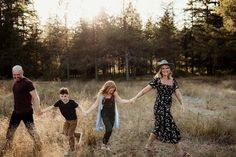 a family holding hands and walking through tall grass