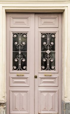 two pink doors with wrought iron designs on them