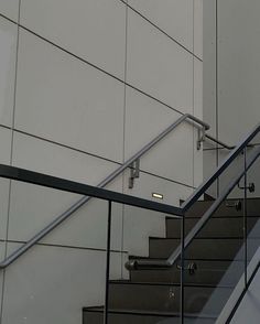 an image of stairs going up and down the wall with glass railings on both sides