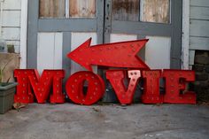 a red sign that says movie with an arrow pointing to the right and another way up