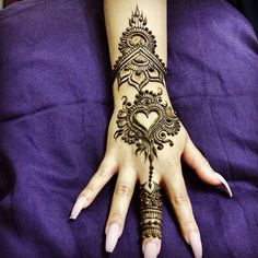 a woman's hand with henna tattoos on it