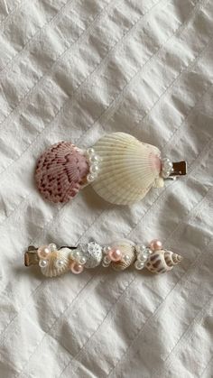 three seashells are laying on a white sheet