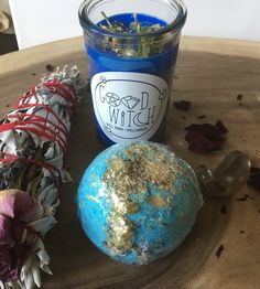 a candle and some flowers sitting on a table next to a blue ball with gold flecks