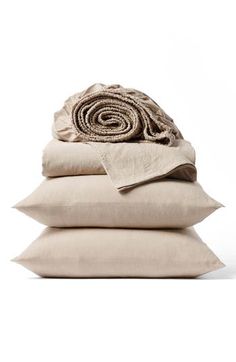 three pillows stacked on top of each other with a blanket folded over the top one