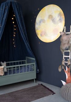 a child's room with a large moon painted on the wall and stuffed animals