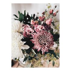 a vase filled with lots of flowers on top of a table