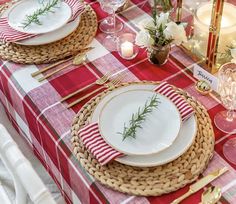 the table is set with red and white plates, silverware, and napkins