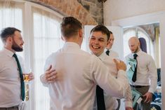 a group of men standing next to each other in front of a mirror with their arms around one another