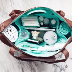 the inside of a purse with all its contents in it on a marble surface,