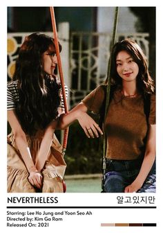 two young women sitting on swings outside at night