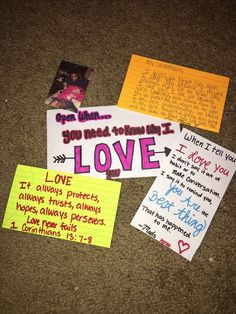 several pieces of paper on the ground with words and pictures written on them, including love