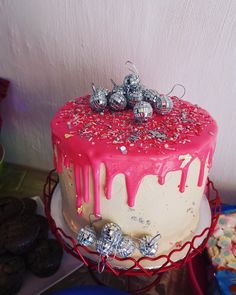 a red and white cake sitting on top of a table next to other desserts