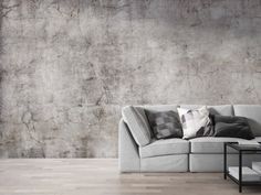 a living room with a couch, coffee table and concrete wall