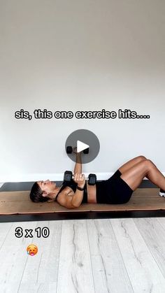 a woman laying on top of a yoga mat with dumbbells in front of her