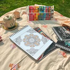 the table is covered with art supplies such as watercolors, pens and books