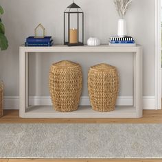 two wicker stools sit under a white table with books and plants on it