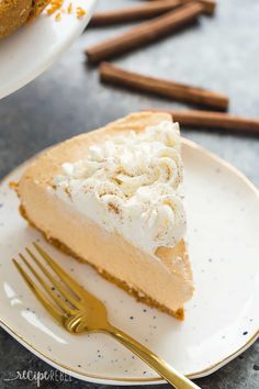 a slice of pumpkin cheesecake on a plate with a fork and cinnamon sticks in the background