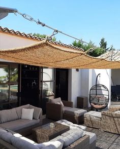 an outdoor living area with wicker furniture and hammock hanging from the roof