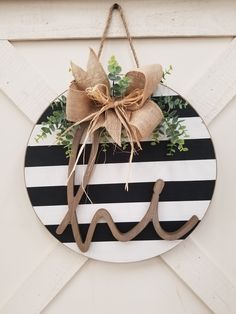 a black and white striped door hanger with a burlock bow on it