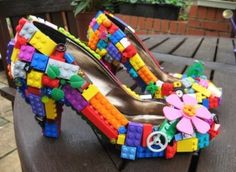 a pair of shoes made out of legos on top of a wooden bench with flowers