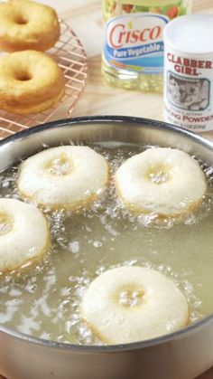 doughnuts are being cooked in a pan on the stove with water and sugar