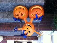 three pumpkins with faces carved into them are hanging from the side of a building