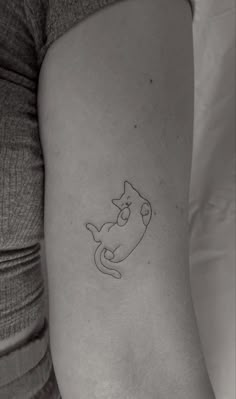 a small cat tattoo on the left inner arm and leg, with an outline of a cat