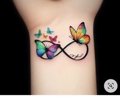 two butterflies on the back of a woman's left arm with an infinite symbol