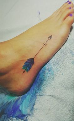 a woman's foot with an arrow tattoo on it