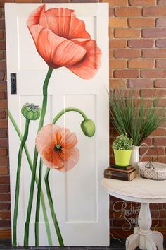 an image of two flowers painted on the door to a brick wall in front of it