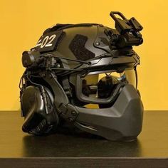 a helmet and goggles are sitting on a table in front of a yellow wall