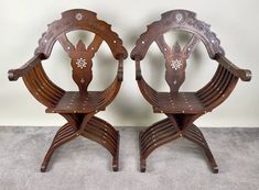 two wooden chairs sitting next to each other