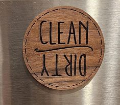 a close up of a metal refrigerator door with a wooden sign on it that says clean albio