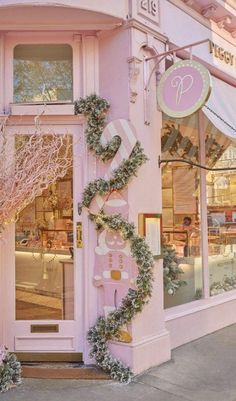 a pink store front with wreaths on the outside