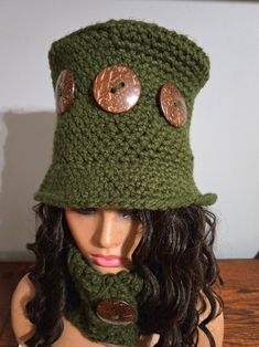 a woman wearing a green hat and scarf with buttons on the front, made to look like she has long hair