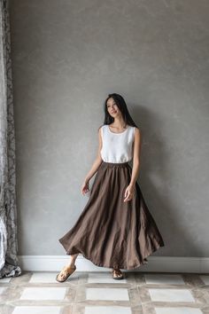 This linen maxi skirt with elastic waist is the perfect addition to any wardrobe. Crafted from high-quality linen, this long skirt is both comfortable and durable, ensuring that it will be a staple in your wardrobe for years to come. Featuring an elastic waist and two side functional pockets, the ABIGAIL linen skirt is designed for maximum comfort and ease of wear. The elastic band allows for a customizable fit, making it perfect for all body types. And with its long length, this linen skirt pro Brown Gathered Flared Maxi Skirt, Flowy Brown Skirt With Elastic Waistband, Brown Flowy Skirt With Elastic Waistband, Brown Gathered Long Skirt, Brown Long Gathered Skirt, Brown Relaxed Full Maxi Skirt, Brown Relaxed Skirt With Elastic Waistband, Brown Full Maxi Skirt For Summer, Brown Flowy Skirt