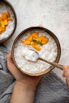 two bowls filled with oatmeal topped with mango slices