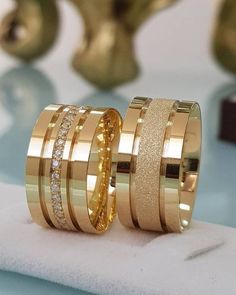 two gold wedding bands with diamonds on them