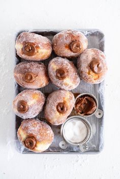 powdered doughnuts with icing and peanut butter on a tray