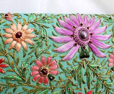 "Stunning one-of-a-kind statement clutch, a lush garden of glowing silk flowers hand embroidered on a rich turquoise/green silk background, and embellished with metallic threads and genuine star ruby stones. The sumptuous luster of silk and the exquisite embroidery make this a show stopping purse! The lotus flower is a symbol of rebirth and new beginnings - perfect for weddings and life's transitions. The word Zardozi means \"gold thread\". It is an elaborate and intricate embroidery using metal Elegant Green Bag With Floral Embroidery, Elegant Green Bags With Floral Embroidery, Green Clutch For Festival Gifts, Green Clutch For Festive Occasions, Green Festive Clutch As A Gift, Handmade Green Clutch For Festivals, Bohemian Green Clutch As Gift, Green Bags With Floral Embroidery As A Gift, Green Clutch Bag For Festivals