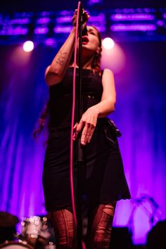 a woman standing on stage holding a microphone