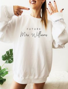 "personalized gift for bride, wedding gift, honeymoon pajamas, bride to be gift, custom bridal gift, bride t-shirt, mrs tee, future mrs ----------------------------------------- Future Mrs. (Last Name) Sweatshirt Welcome to Bride Bikini® Etsy Shop! This listing is for one ultra soft UNISEX FIT sweatshirt that says \"Future Mrs. (your last name)\" on the front chest. On the sleeve we will print \"I SAID YES\" as shown in the listing photo. **Please leave a note at checkout with the design and let Perfect Engagement Gifts, Mrs Sweatshirt, Engaged Shirts, Bride Sweatshirt, Mrs Shirt, Bride Shirt, I Said Yes, Personalized Bride