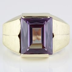 Vintage 12k Brushed Yellow Gold Lab-Created Alexandrite Anniversary Ring C.1970 This Vintage Men's Ring Is Made Of 12 Karat Yellow Gold And Features An Emerald-Cut Lab-Created Alexandrite Gemstone (12mm X 10mm) That Shines Shades Of Purple And Blue At Different Angles. The Band Has A Brushed Texture And A Smooth Inner Texture For Easy Wear. This Size 8.75 Ring Can Be Resized By Any Qualified Jeweler. Size: 8.75 Metal: 12 Karat Yellow Gold Weight: 4.84 Dwt / 7.52 Grams Gemstone: Lab Created Alexandrite (12mm X 10mm) I-2978 *E-Rdc Alexandrite Gemstone, Antique Jewelry Rings, Mens Accessories Jewelry, Men's Ring, Anniversary Ring, Shades Of Purple, Purple Gold, Emerald Cut, Easy Wear